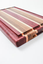 Load image into Gallery viewer, Handmade cutting board with strips of purpleheart, walnut and maple wood featuring a juice groove.
