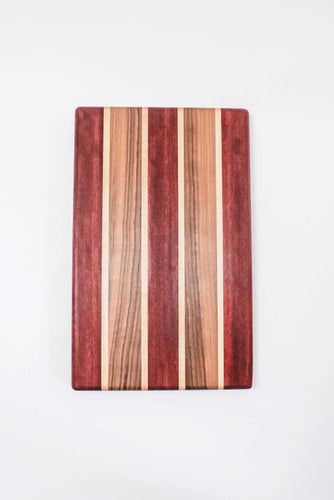 Handmade cutting board with strips of purpleheart, walnut and maple wood. 