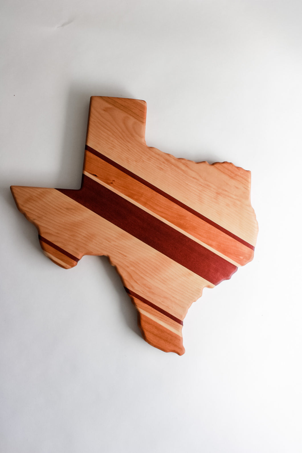 Texas shaped cutting board made with cherry, maple, and purpleheart
